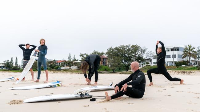 Brownlow medallist Nat Fyfe (centre), premiership player Jack Darling and young ruckman Callum Jamieson hit the waves with surfing legend Mick Fanning (right).