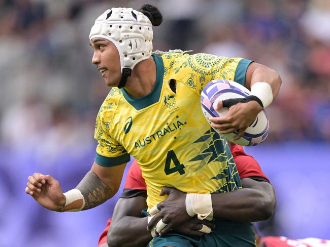 Kenya's Samuel Asati (back) tackles Australia's Dietrich Roache (front) during the men's pool B rugby sevens match between Australia and Kenya during the Paris 2024 Olympic Games at the Stade de France in Saint-Denis on July 24, 2024. (Photo by CARL DE SOUZA / AFP)