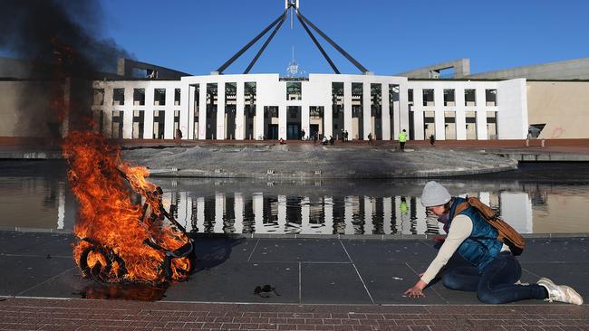 Extinction Rebellion protesters set fire to a pram and glued their hands to the Parliament House forecourt in Canberra. Picture: Gary Ramage