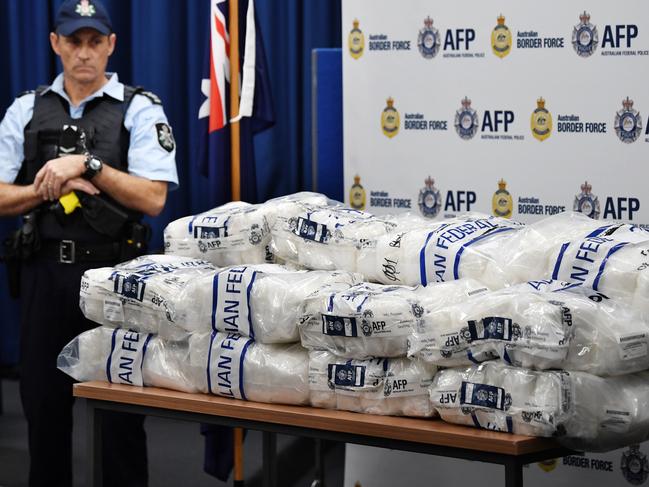 An AFP officer looks on as bags of crystal methamphetamine are seen on a table. Picture: David Moir