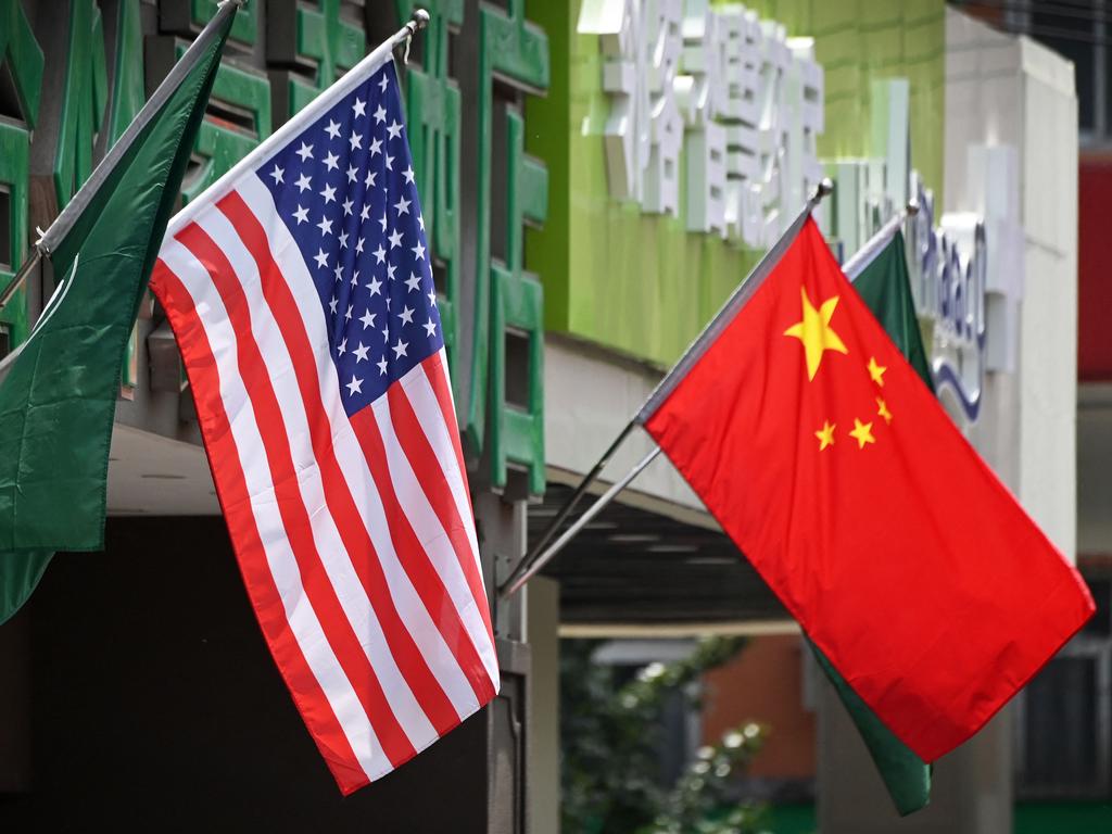 An American flag is seen flying beside a Chinese flag in Beijing, but the reality is that the two superpowers do not always see eye-to-eye. Picture: Greg Baker/AFP