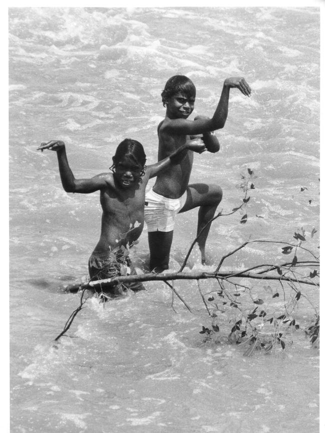 Borroloola children play in a flooded river after Kathy.