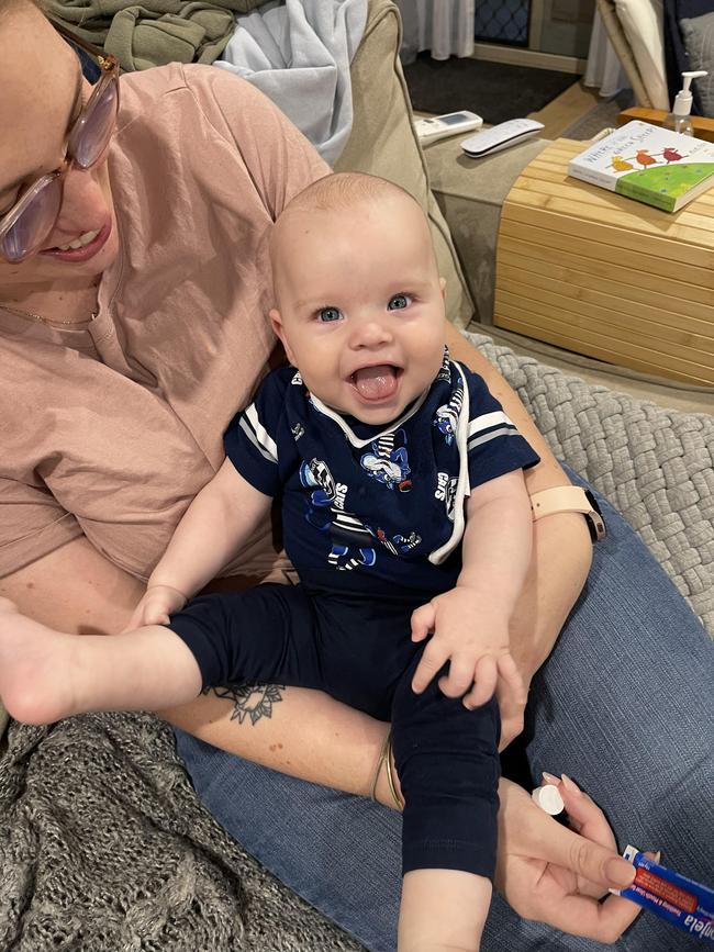 Elijah Feeley. Six months old. My daddy pa barrack for Collingwood but my mummy barracks for Geelong, so I wear Geelong gear when they are playing Collingwood when they play. As you can see, I’m always happiest when I have mummy’s team colours on.