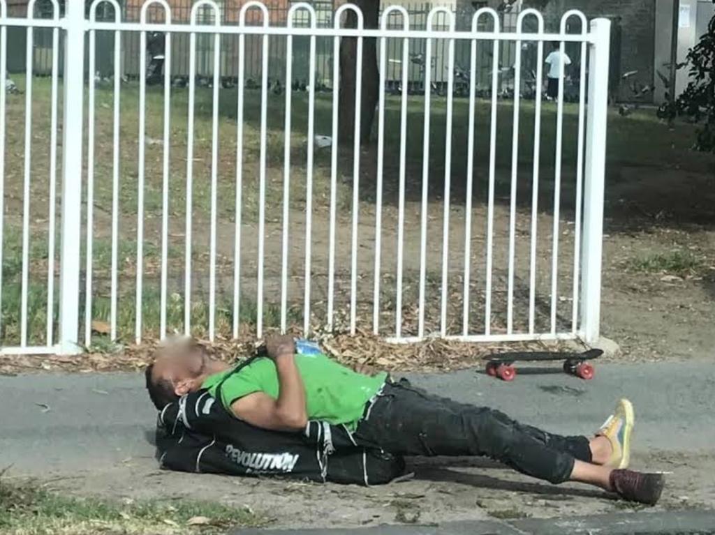 A man motionless on the ground near the injecting room. Picture: Supplied