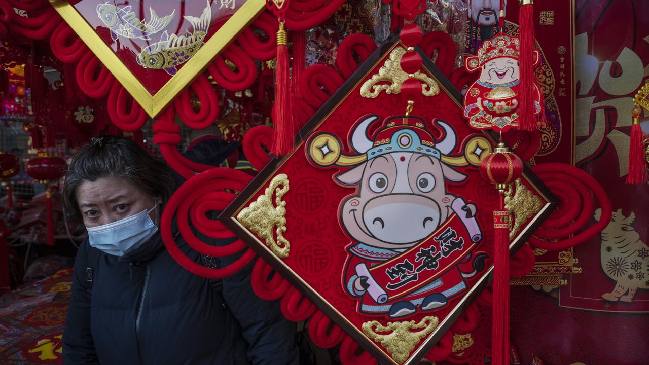 A woman wears a protective mask as she shops for traditional festive decorations for the upcoming Chinese New Year marking the Year of the Ox at a shopping area in Beijing, China. Celebrations will be a little different this year as we work to stop the spread of the coronavirus. Picture: Getty Images