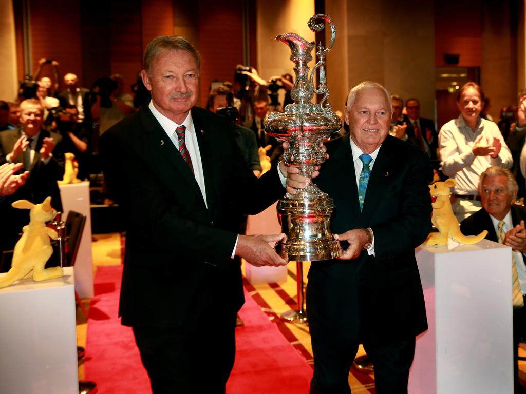 John Bertrand and Alan Bond carry the America’s Cup into the luncheon watched by Bob Hawke to commemorate the 30th Anniversary of Australia II’s America’s Cup victory at the Hilton Hotel. Sydney. Picture: Gregg Porteous