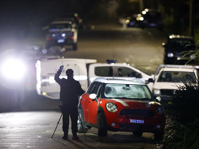 The possible getaway car (red) next to a burnt-out car on Annette St in Oatley. Picture: Jonathan Ng