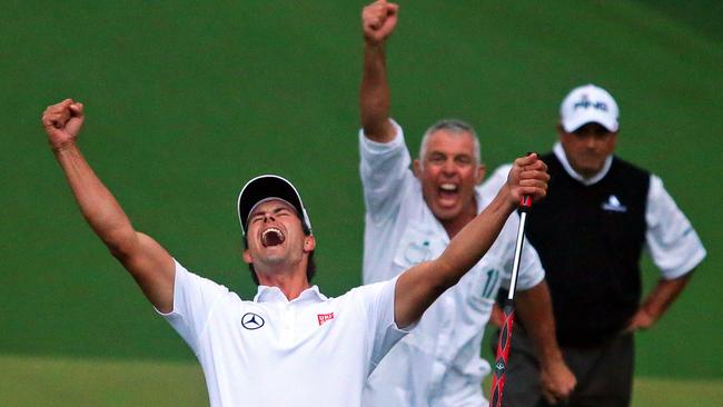 Adam Scott and his caddie Steve Williams reacts to his putt dropping on the second hole of a playoff to win the Masters