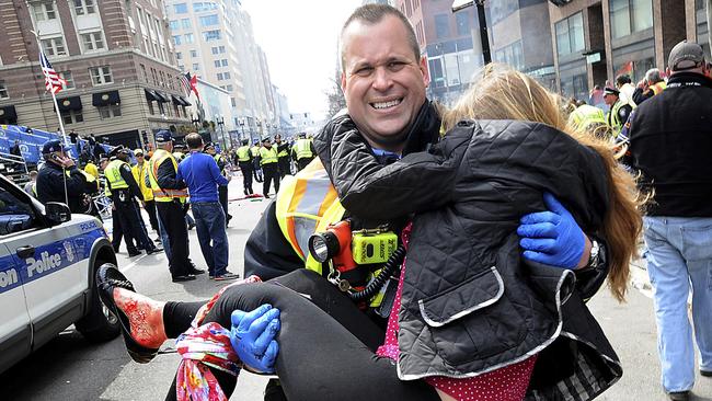 A firefighter carries an injured girl from the scene of the Boston Marathon bombing in 2013. Picture: AP