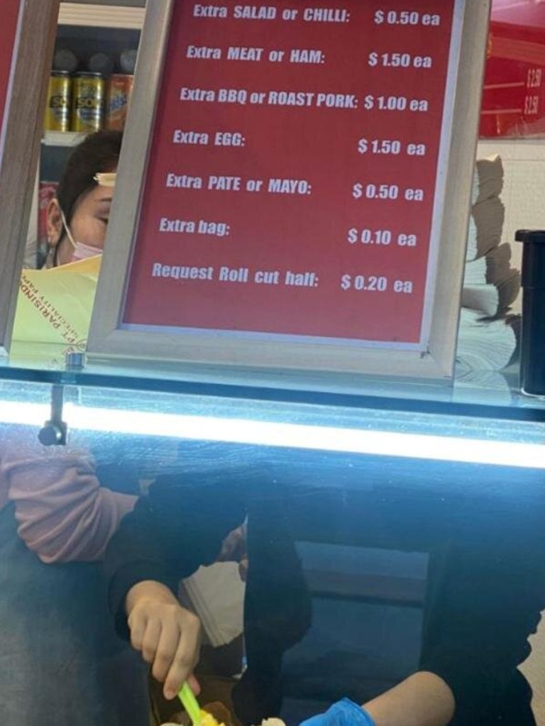 The Sydney Pork Rolls sign says ‘Request Roll cut half: $0.20ea’.