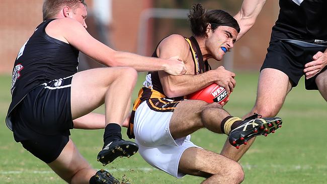 Blake Marshall (Modbury) is tackled by Simon Sharley (Adelaide University) during the first quarter last week. Picture: Stephen Laffer