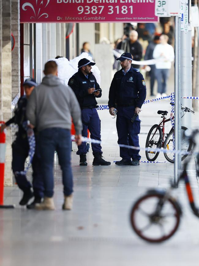 Police are pictured near the building’s entrance on Spring Street in Bondi Junction. Picture: Richard Dobson