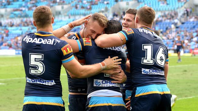 Michael Gordon of the Titans is congratulated by Bryce Cartwright and teammates after scoring a try. Picture: Bradley Kanaris/Getty Images