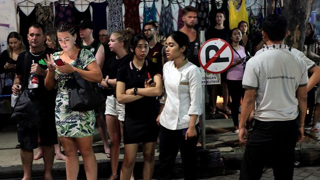 Foreign tourists and hotel staff stand on the street after being evacuated in Bali's capital, Denpasar. Picture: AFP