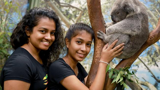 Featherdale visitors Rukghani Cuoray and her sister-in-law Dinuvi Dahamthi pose for photographs with a koala at Featherdale Wildlife Park. Picture: Angelo Velardo