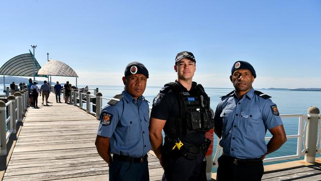 Constable Nathan Garreffa with PNG cadet graduates Alois Ulne and Pascal Hauramiri on the Strand. Picture: Evan Morgan