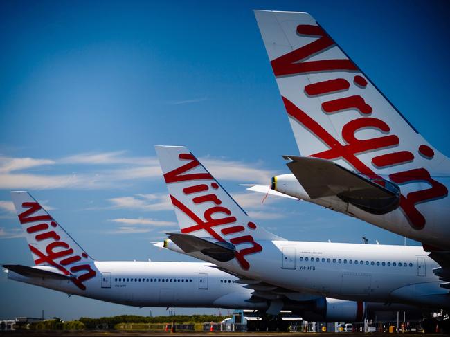 Virgin Australia aircraft are seen parked on the tarmac at Brisbane International airport on April 21, 2020. - Cash-strapped Virgin Australia collapsed on April 21, making it the largest carrier yet to buckle under the strain of the coronavirus pandemic, which has ravaged the global airline industry. (Photo by Patrick HAMILTON / AFP)