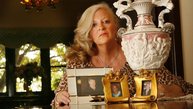 Judy Moran at home with pictures of her dead family and an urn with the ashes of partner Lewis.