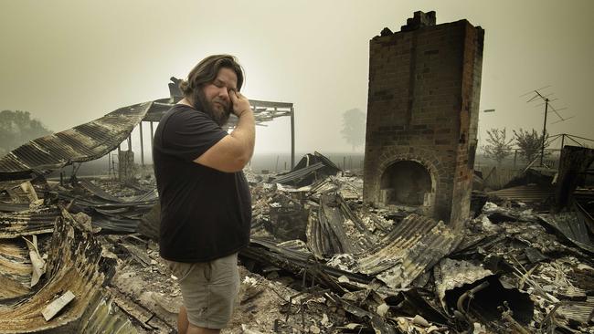 Josh Collings returns to his burnt home days after being cut off by the fire in Main St, Cudgewa. Picture: Tony Gough