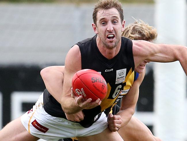 VFL. Sandringham v Werribee at Trevor Barker Oval, Sandringham.  Werribees Michael Barlow looks to give by hand whilst being tackled  .  Pic: Michael Klein