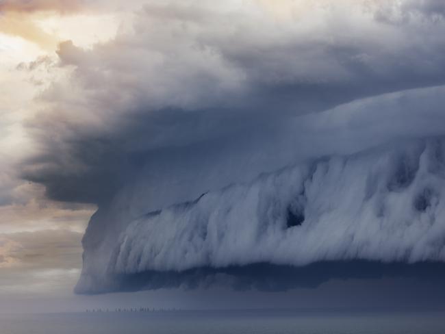 Tiny sailing boat and incoming storm