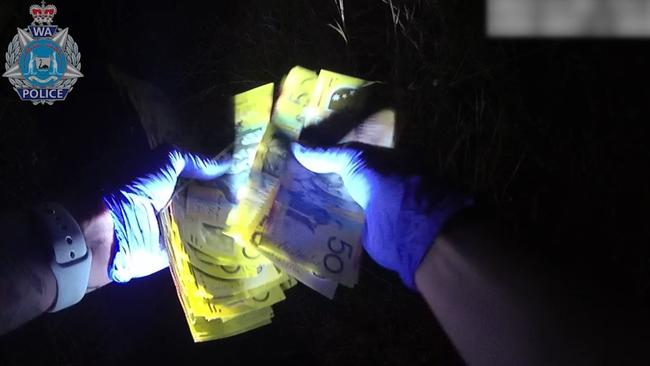 Body worn camera vision from the scene shows police officers scrambling to pick up bundles of notes. Picture: Supplied / WA Police