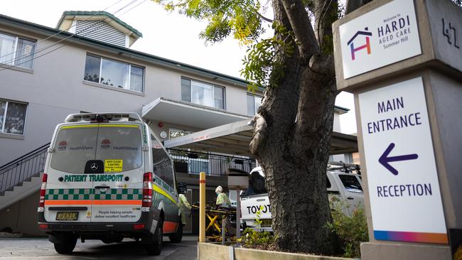 Ambulance attendants wearing full protective clothing prepare a gurney to transport residents to hospital at the Wyoming Nursing Home. Picture: Getty Images