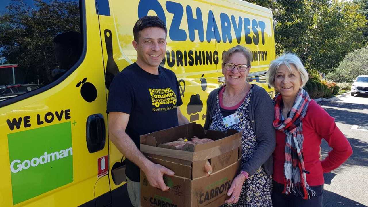 Oz Harvest driver (far left) Gareth Walpole delivers food to Paula Caid (centre) and Bea Kressig.