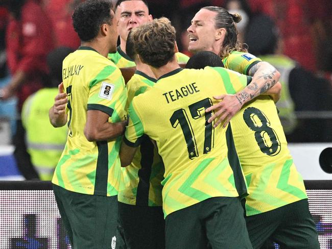 Australia's Jackson Irvine (R) celebrates with teammates after scoring a goal during the 2026 FIFA World Cup qualification football match between China and Australia at the Hangzhou Olympic Sports Center Stadium in Hangzhou, in China's eastern Zhejiang province on March 25, 2025. (Photo by Hector RETAMAL / AFP)