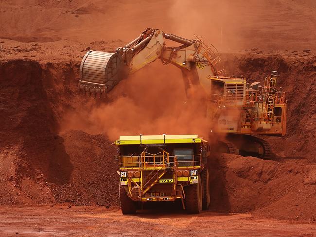 An excavator loads ore into an autonomous dump truck at Fortescue Metals Group Ltd.'s Solomon Hub mining operations in the Pilbara region, Australia, on Thursday, Oct. 27, 2016. Shares in Fortescue, the world's No. 4 iron ore exporter, have almost trebled in 2016 as iron ore recovered, and the company cut costs and repaid debt. Photographer: Brendon Thorne/Bloomberg via Getty Images