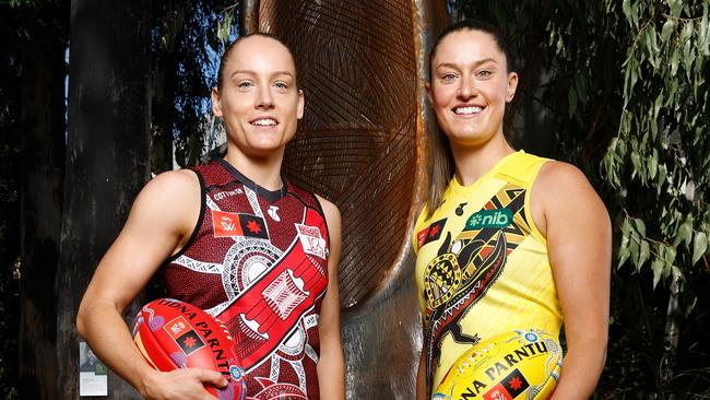 MELBOURNE, AUSTRALIA - OCTOBER 21: Stephanie Cain, Co-Captain of the Bombers and Maddie Shevlin of the Tigers pose in front of 'The Sacred Tree of our Songlines' created by Gunnai and Waradjurie man Robert Michael Young during the 2024 AFLW Indigenous Round Launch at Melbourne Museum on October 21, 2024 in Melbourne, Australia. (Photo by Michael Willson/AFL Photos via Getty Images)