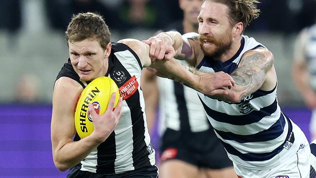 MELBOURNE, JULY 12, 2024: 2024 AFL PREMIERSHIP - Round 18 - Collingwood Magpies v Geelong Cats at the MCG. Will Hoskin-Elliott of the Magpies shrugs off Geelong Cat Zach Tuohy. Picture: Mark Stewart