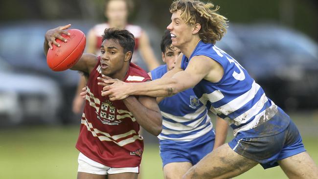 PAC’s Kysaiah Pickett, beaks away from a tackle by St. Peter’s Sam Dukalskis. Picture: AAP Image/Dean Martin