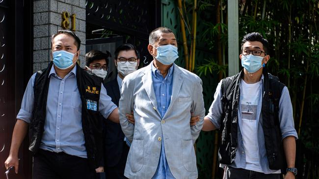 Police lead away Jimmy Lai on Monday. Picture: AFP