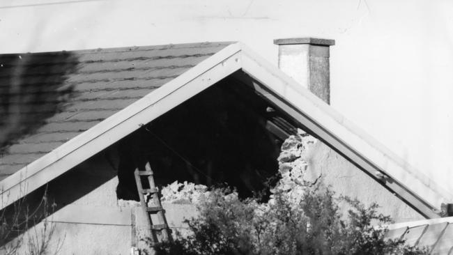 The hole police smashed in the side of Grosser's rented house to expose his hiding place.