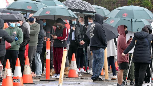 People lined up at Epping in the rain to get tested for COVID-19 on Wednesday. Picture: David Crosling