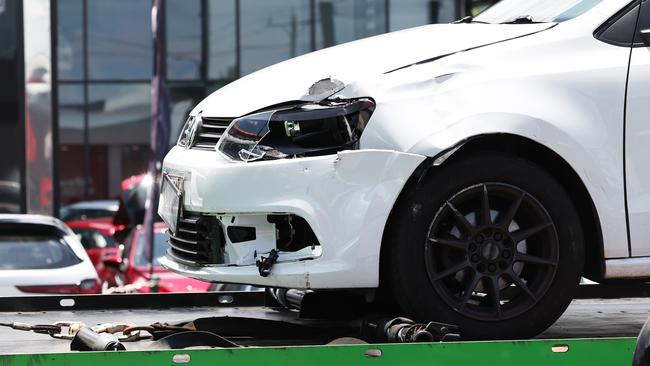 Emergency services personnel attend the scene of a traffic crash between a small car and a scooter at the intersection of Mulgrave Road and Newell Street, Bungalow. The car involved in the crash is towed away from the scene. Picture: Brendan Radke