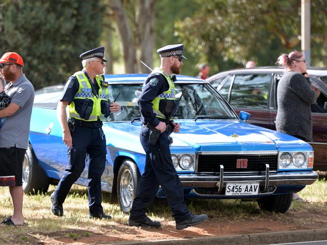 Police officers order cars to be removed from the median outside the Holden plant. Picture: AAP