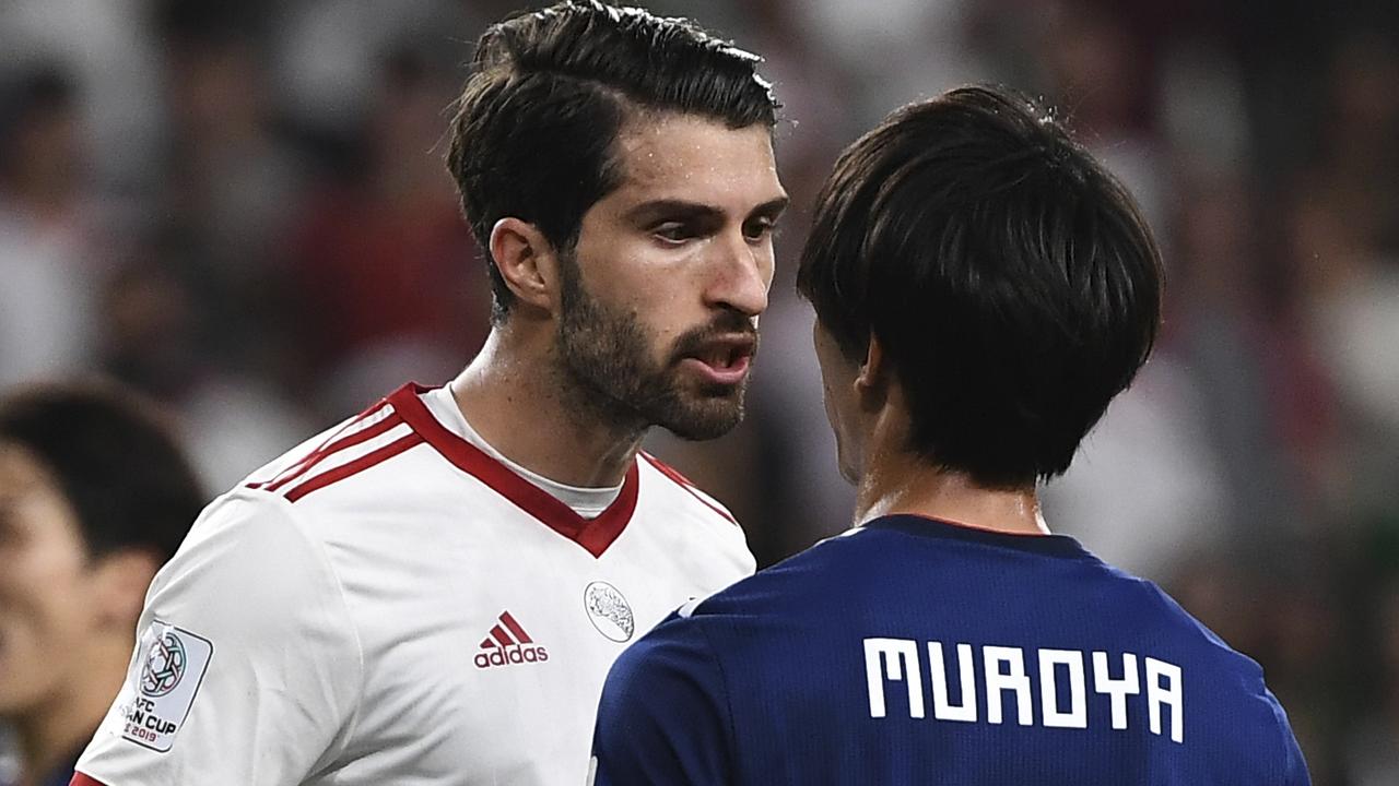 Iran's forward Karim Ansarifard argues with Japan's defender Sei Muroya. 