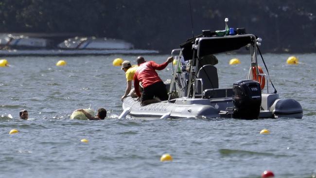 The Serbian team are helped out of the water after capsizing their boat