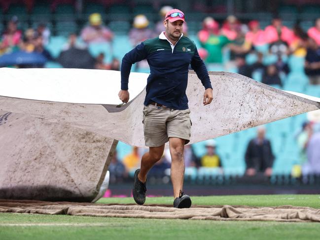 Groundsmen cover the pitch during a rain delay during the Test match between Australia and South Africa at the Sydney Cricket Ground. Picture: David Gray/AFP