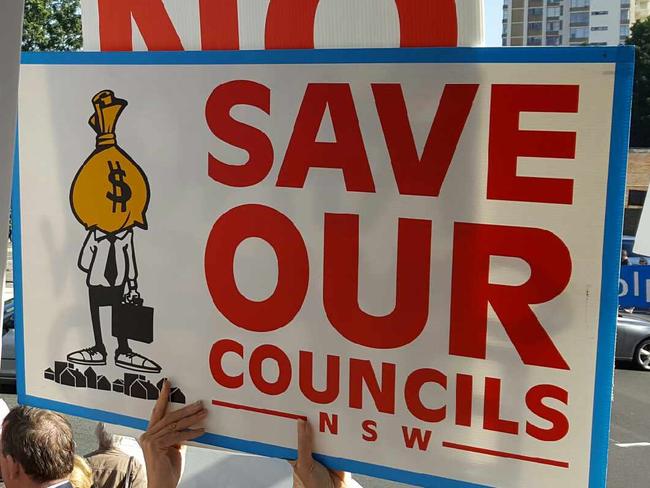 A small but vocal crowd gathers outside Malcolm Turnbull's electorate office, campaigning against council mergers.