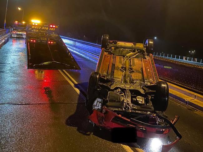 A car is retrieved by TNT Towing after it veered into the kerb on the Grafton Bridge and flipped on its roof. Pictures: TNT Towing.