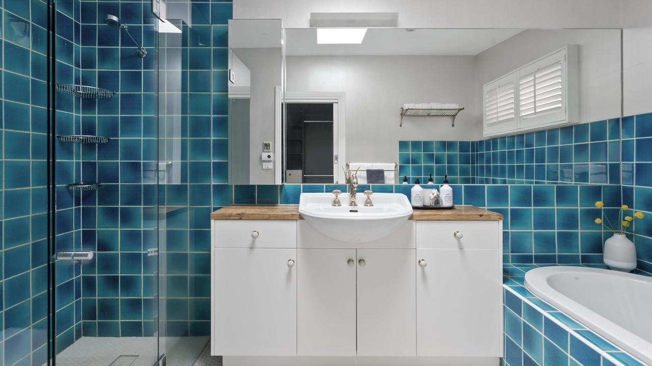 Blue tiles and a bathtub in one of the two bathrooms.