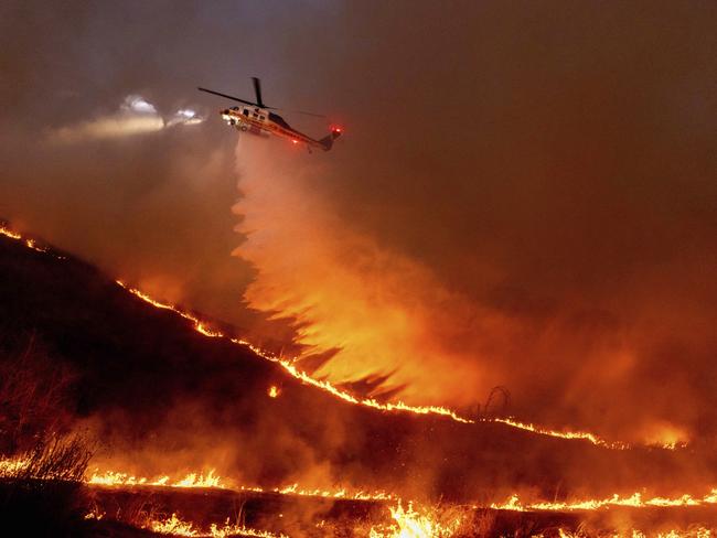 Water is dropped by helicopter on the Kenneth Fire in the West Hills section of Los Angeles, Thursday, Jan. 9, 2025. (AP Photo/Ethan Swope)