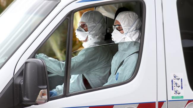 Paramedics wear hazmat suits arrive at Avalon Airport while attending a coronavirus scare. Picture: Glenn Ferguson