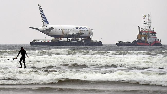 A paddle boarder is seen as Boeing 767 airplane arrives the Enniscrone estuary after it was tugged from Shannon airport out t...