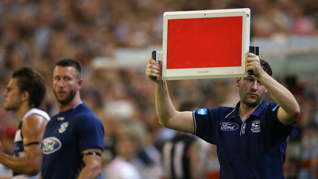 Geelong officials try to get a message to their players. Picture: Michael Klein.