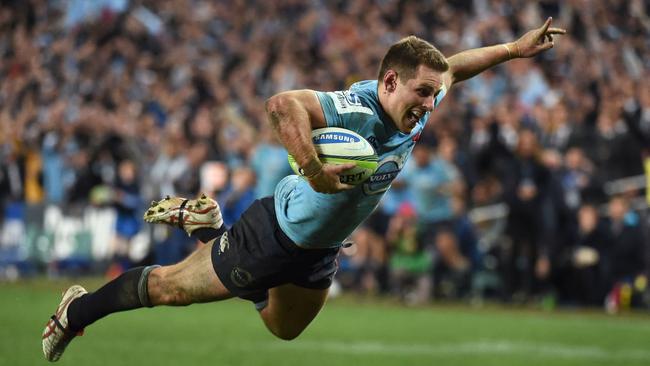 Waratahs flyhalf Bernard Foley dives over to score a try.