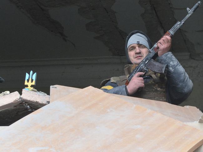 An armed man inside the damaged local city hall of Kharkiv. Picture: AFP